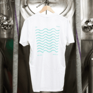 Front of "Waves T-Shirt" hanging from stainless tank